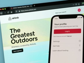 The login page for Airbnb's iPhone app is seen in front of a computer displaying Airbnb's website on May 8, 2021, in Washington.