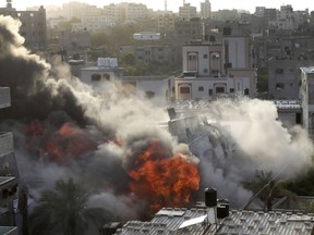 Smoke and fire rise from an explosion caused by an Israeli airstrike targeting a building in Gaza, Saturday, May 13, 2023.
