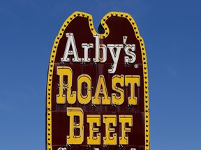 A sign is displayed outside of an Arby's restaurant