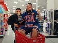 Man holding two bottles being pushed in Target cart