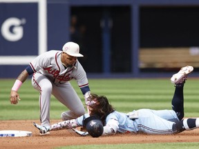 Orlando Arcia of the Atlanta Braves tags Bo Bichette of the Toronto Blue Jays at second at Rogers Centre on May 14, 2023 in Toronto.
