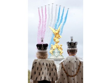 A handout image released by Buckingham Palace showing King Charles III and Queen Camilla as they watch the flypast from the balcony of Buckingham Palace after their coronation on May 6, 2023 in London.