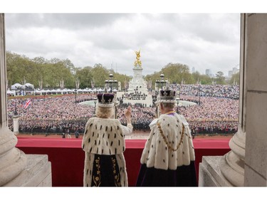 In This handout image released by Buckingham Palace, King Charles III and Queen Camilla wave from the balcony of Buckingham Palace after their Coronation on May 6, 2023 in London.