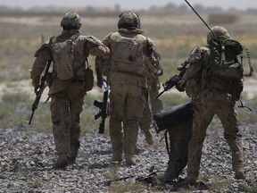 Canadian soldiers help a comrade get on a helicopter in Kandahar