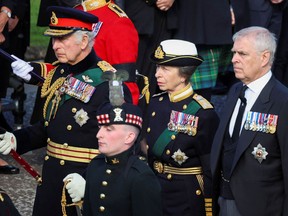 King Charles III (left), Princess Anne, and Prince Andrew walk behind the procession of Queen Elizabeth II's coffin on the Royal Mile on September 12, 2022.