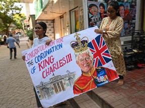 Art school students carry a painting depicting King Charles III ahead of his coronation, in Mumbai on May 5, 2023.