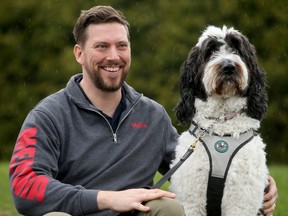 Cory Taylor, seen here with his service dog Cueinn - a six-year-old Sheepadoodle - outside of his Casselman home, is much happier these days. The retired military investigator got PTSD after serving in Afghanistan, leaving him struggling to even string sentences together, until he learned about a treatment used on U.S. veterans.