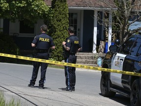 Two officers from the OPP Northumberland detachment guard the scene on Friday, May 26, 2023, a day after a toddler under two years old allegedly wandered away from a day care just north of Cobourg and was later found dead in a nearby well.