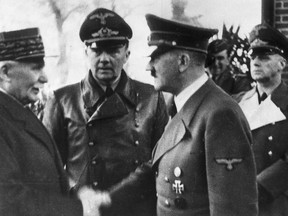 This  Oct. 24, 1940 file photo shows German Chancellor Adolf Hitler, right, shaking hands with Head of State of Vichy France Marshall Philippe Petain, in occupied France. Behind centre is Paul Schmidt an interpreter and right is German Minister of Foreign Affairs Joachim Von Ribbentrop.