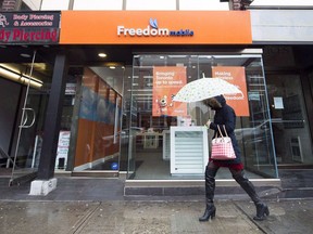 A woman walks past a Freedom Mobile store in Toronto