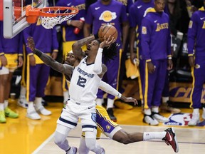 Memphis Grizzlies' Ja Morant (12) drives to the basket against Los Angeles Lakers' Jarred Vanderbilt during the first half in Game 6 of a first-round NBA basketball playoff series Friday, April 28, 2023, in Los Angeles.