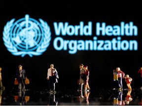 Small figurines are seen in front of displayed World Health Organization logo in this illustration taken February 11, 2022.