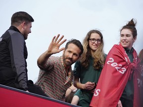 Wrexham co-owner Ryan Reynolds, center, celebrates with members of the Wrexham FC soccer team the promotion to the Football League in Wrexham, Wales, Tuesday, May 2, 2023.