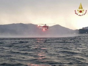 In this image released by the Italian firefighters a helicopter search for missing after a tourist boat capsized in a storm on Italy's Lago Maggiore in the northern Lombardy region, Sunday, May 28, 2023.