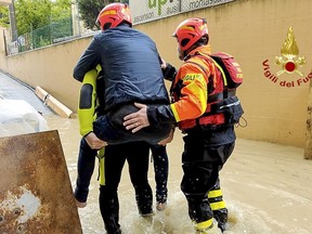 This photo provided by the Italian Firefighters shows firefighters rescuing a person from a flooded house in Riccione, in the northern Italian region of Emilia Romagna, Tuesday, May 16, 2023. Unusually heavy rains have caused major flooding in Emilia Romagna, where trains were stopped and schools were closed in many towns while people were asked to leave the ground floors of their homes and to avoid going out. (Vigili del Fuoco via AP)