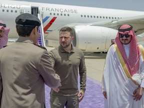 In this photo provided by Saudi Press Agency, SPA, Ukraine's President Volodymyr Zelenskyy, second right, is greeted by Prince Badr Bin Sultan, deputy governor of Mecca, right, upon his arrival at Jeddah airport, Saudi Arabia, Friday, May 19, 2023.