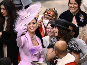 Katy Perry takes selfies with guests during the Coronation of King Charles III and Queen Camilla on May 6, 2023 in London.