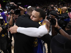Stephen Curry of the Golden State Warriors hugs LeBron James of the Los Angeles Lakers after the Western Conference Semifinal Playoff game at Crypto.com Arena on May 12, 2023 in Los Angeles, Calif.