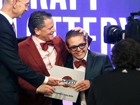In this May 21, 2013, file photo, Cleveland Cavaliers owner Dan Gilbert congratulates his son, Nick Gilbert, after the team won the NBA basketball draft lottery in New York.
