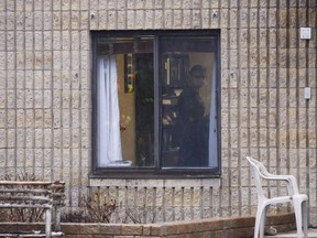 A worker is shown through a window at a long-term care home in Almonte, Ont. on Thursday, April 9, 2020.