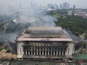 Smoke billows from the still smoldering Manila Central Post Office as a fire hits early Monday, May 22, 2023 in Manila, Philippines. A massive fire tore through Manila's historic post office building overnight, police and postal officials said Monday.