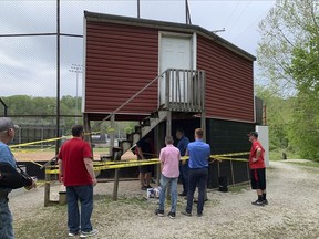 In this photo provided by WSAZ, people stand behind caution tape as they look at a press box that partially collapsed at the softball field at Wayne High School in Wayne W.Va., Saturday, April 29, 2023.