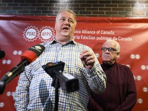 Marc Briere, National President of the Union of Taxation Employees, participates in a news conference as Chris Aylward, PSAC national President looks on, on the negotiations with Canada Revenue Agency, as PSAC-UTE members, who comprise a component of the Public Service Alliance of Canada (PSAC), remain on strike, in Ottawa, on Wednesday, May 3, 2023.