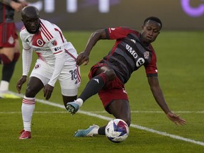 Toronto FC midfielder Richie Laryea (22) goes to ground to control the ball as New England Revolution midfielder Ema Boateng (18) defends during first half MLS soccer action in Toronto on Saturday May 6, 2023.