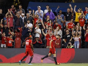 Fans cheer as Toronto FC forward Ifunanyachi Achara (99) and teammate Jesús Jiménez (9) celebrate Jimenez's goal in second half MLS soccer action against the Los Angeles Galaxy in Toronto on Wednesday, Aug. 31, 2022.