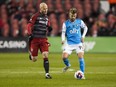 Toronto FC midfielder Michael Bradley (4) battles for the ball against Charlotte FC midfielder Chris Hegardt (19) during second half MLS soccer action in Toronto, on Saturday, April 1, 2023. TFC coach Bob&ampnbsp;Bradley revealed Thursday that captain Michael Bradley, his son, was scheduled to leave for England later Thursday to undergo a procedure Saturday in London on his hamstring. THE&ampnbsp;CANADIAN PRESS/Andrew Lahodynskyj