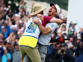 Nick Taylor celebrates with his caddie.
