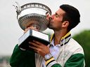 Novak Djokovic kisses the Musketeers' Trophy.