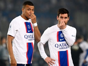 Paris Saint-Germain's Kylian Mbappe speaks with Lionel Messi.