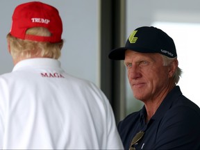 Former US President Donald Trump (L) talks with LIV Golf CEO Greg Norman.