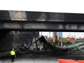 Workers inspect and clear debris from a section of bridge that collapsed on Interstate 95 after an oil tanker explosion on June 12, 2023 in Philadelphia, Pennsylvania. Traffic was severely affected due to the closure of this primary north-to-south highway for East Coast travel. (Photo by Mark Makela/Getty Images)