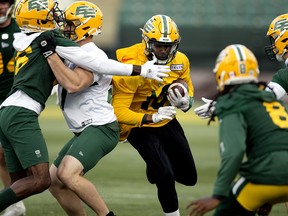 Kai Locksley (centre) runs the ball during an Edmonton Elks practice last month. Locksley was released on Monday.