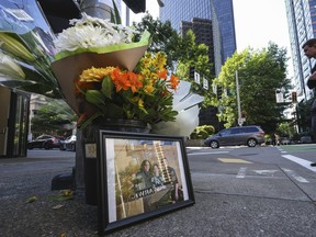 A bouquet of flowers and a photograph on the corner of Lenora St. and 4th Avenue, Thursday, June 15, 2023 in Seattle.