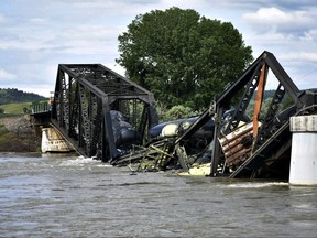 Several train cars are immersed in the Yellowstone River after a bridge collapse near Columbus, Mont.