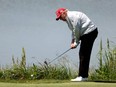 Former U.S. President Donald Trump chips to the 11th green during the pro-am prior to the LIV Golf Invitational - DC at Trump National Golf Club in Sterling, Va., May 25, 2023.