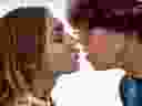 Close up de um jovem casal fumando maconha e prestes a se beijar