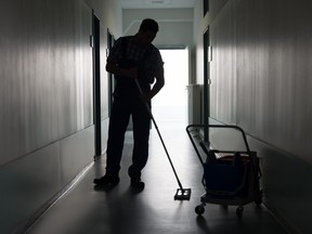 Man With Broom Cleaning Office Corridor