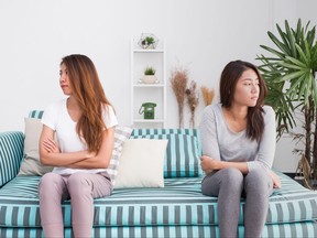 Two women sit in living room.