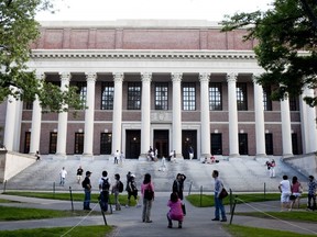Tourists gather in front of the Harry Elkins Widener Library on the campus of Harvard University in Cambridge, Mass