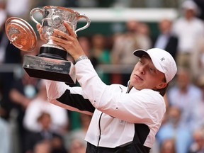 Iga Swiatek of Poland celebrates with her winners trophy as the lid falls off after her victory against Karolina Muchova of Czech Republic in the women's final at the 2023 French Open at Roland Garros in Paris, Saturday, June 10, 2023.