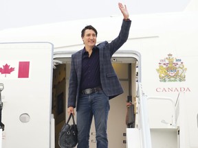 Justin Trudeau waves before boarding airplane