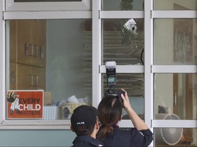 Toronto Police Forensics Det.-Const. Rhonda Haley takes images after a bullet pierced a window at the St. Lawrence Co-Op daycare on Market St. on Tuesday, June 27, 2023.