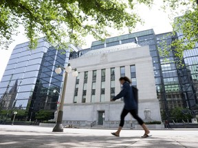 A woman walks past the Bank of Canada headquarters