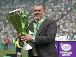 Celtic manager Angelos Postecoglou celebrates with the league trophy after winning the Scottish Premiership, at Celtic Park, Glasgow, Scotland, Saturday, May 27, 2023.