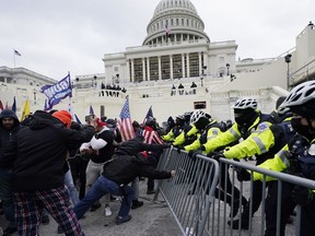 Rioters supporting President Donald Trump try to break through a police barrier at the Capitol