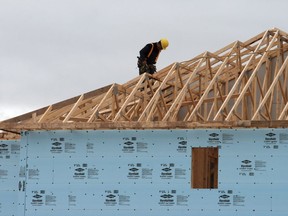 A construction worker works on a house in a new housing development in Oakville, Ont